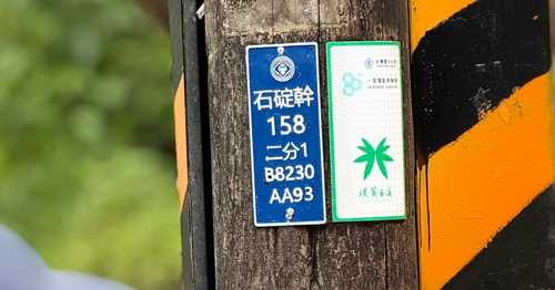 你有留意過嗎？電線桿上常見到一面藍色的電桿牌，電線桿上的「B8230 AA93」即為「電力座標」。（圖片來源：台灣千里步道協會提供之「當國家綠道遇見電火柱」活動）
