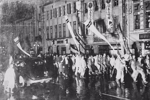 1937年，一群高校生在臺北京町的燈光之下舉辦遊行的場景。