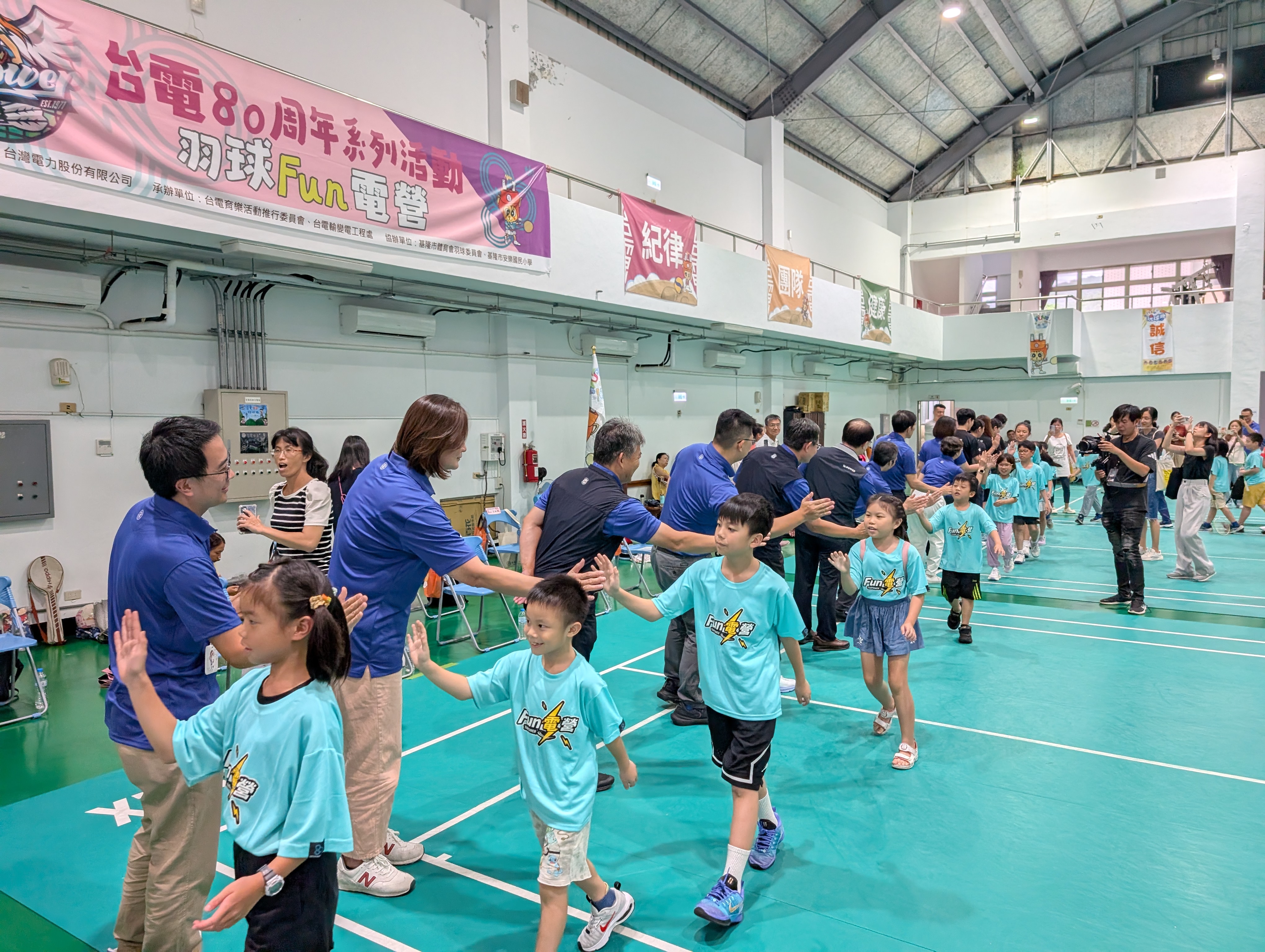 台電持續推廣全民運動，透過「80周年系列活動－羽球Fun電營」帶領學童享受羽球樂趣，活動中與長官擊掌互動，現場洋溢活力與歡樂氣氛。